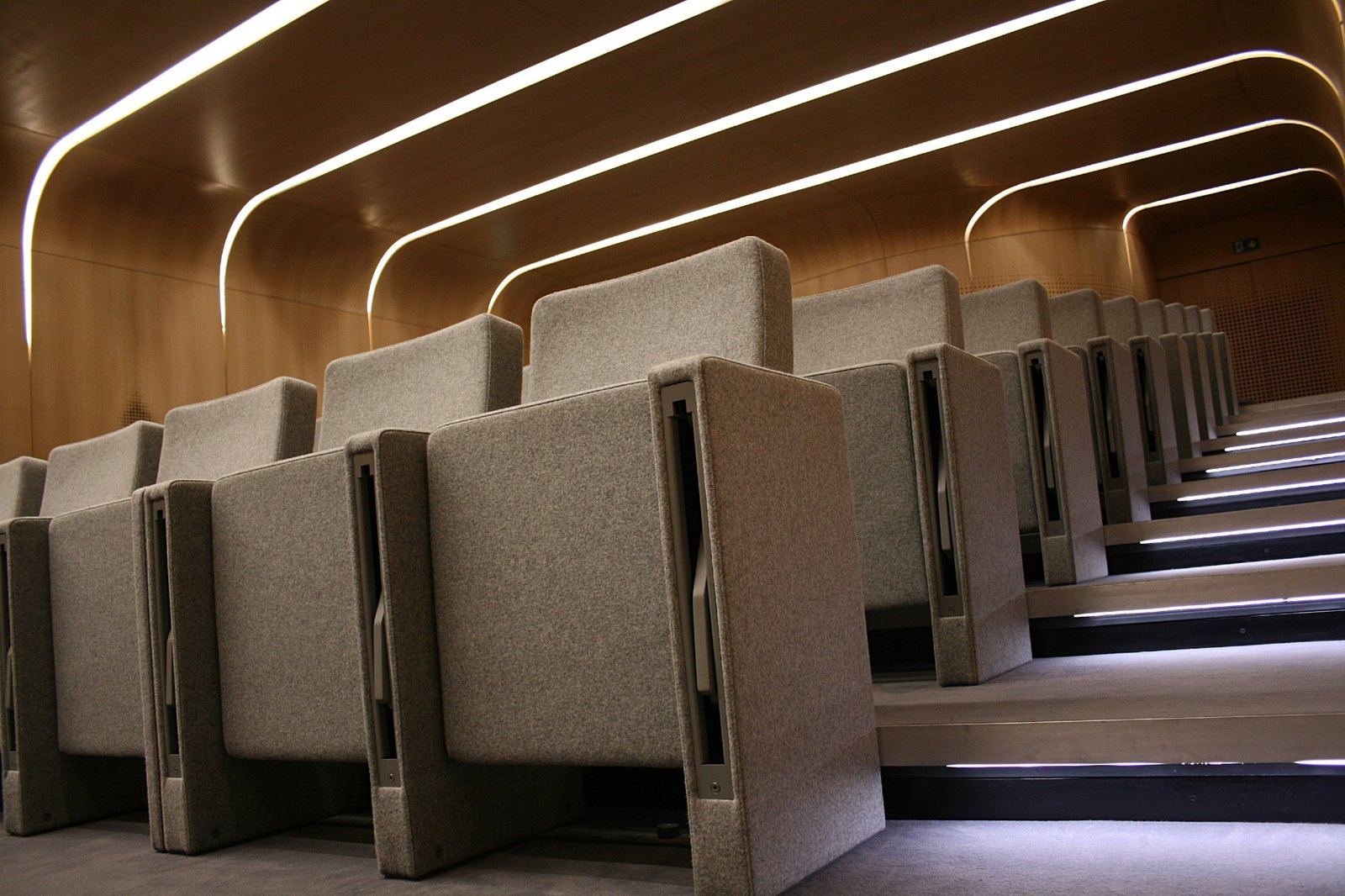 Butacas Rubick en gradas de un auditorio con paneles de madera, vistas desde los costados tapizados