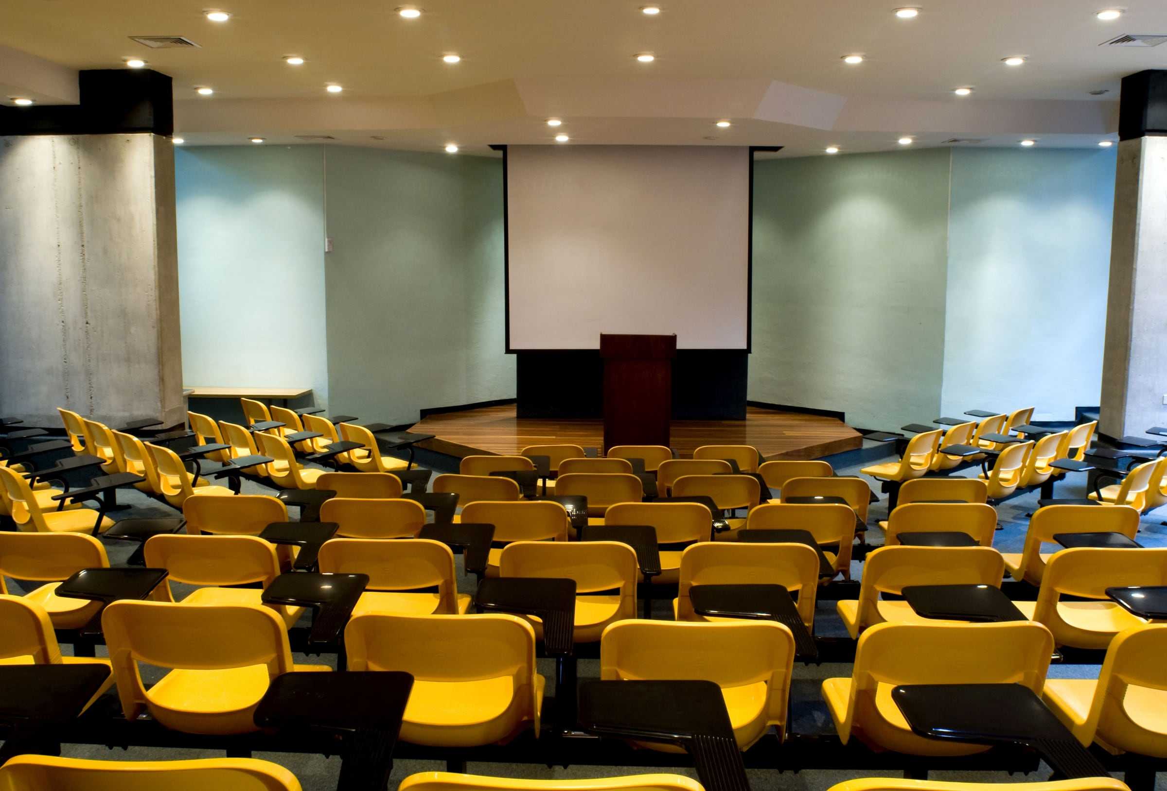 Auditorio de la Facultad de Salud de la UCR con butacas amarillas con paleta